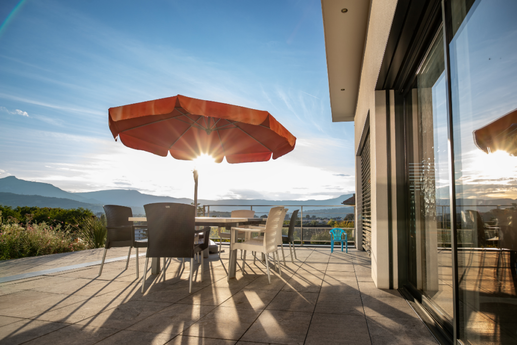 Terrasse baignée de lumière d'une maison individuelle construite par Maisons Alpes Savoie à Barby, en Savoie.